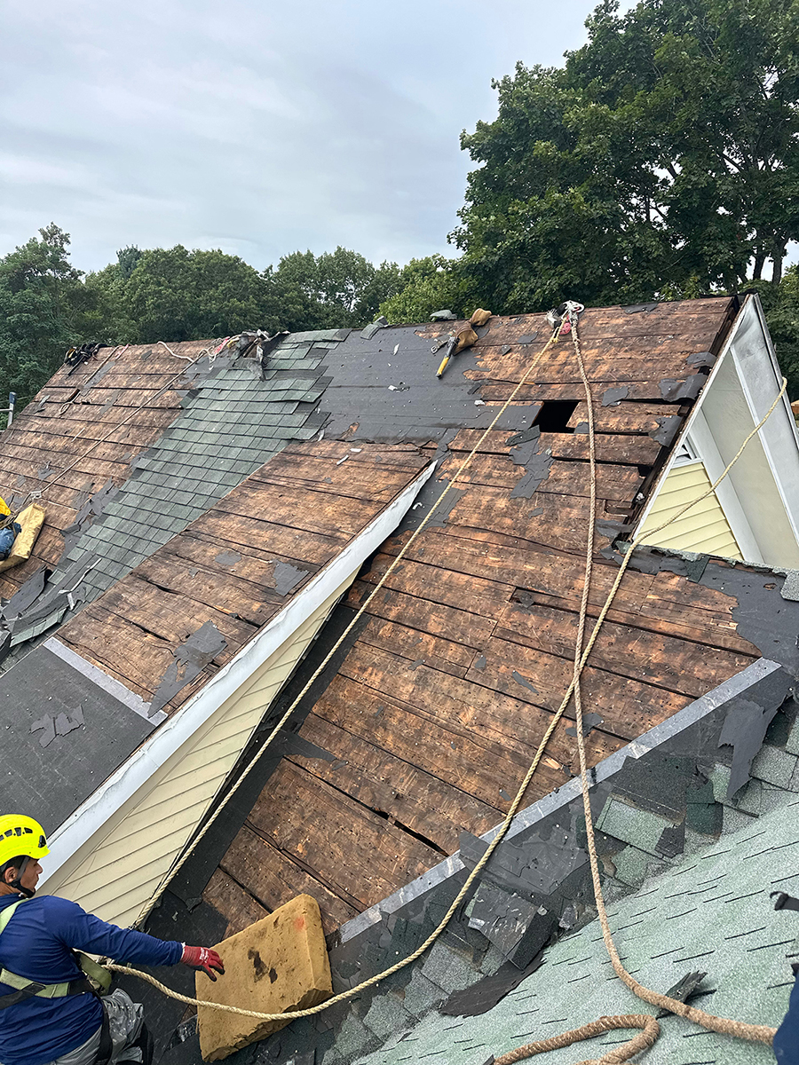 Loja Service crew safely tearing off storm-damaged shingles