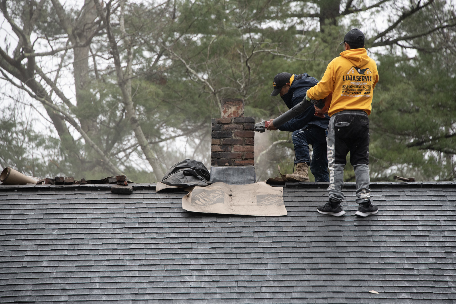 Loja crew performing chimney repair on a roof